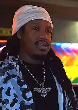 A black man with braids silver chain with an eagle on its end