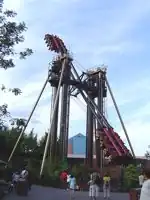 Slammer, a thrill ride at Thorpe Park in England. The ride carried up to 48 people in 2 groups of 24; each group is seated at one end of a long arm, with the groups facing each other. When in operation, the arm rotated about the center, inverting the riders, then stops and reverses.