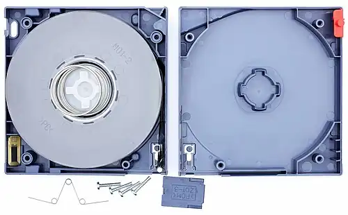 LTO-3 cartridge with the top shell removed, showing the internal components. Top right corner: write-protect-tab. Bottom left corner: cartridge memory chip. Bottom: tape access gate.