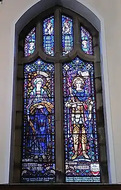 Stained glass window that depicts Saint Michael and displays the Gurkha Rifles regimental badge.