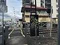 Station Street level crossing signal box and pedestrian gates, adjacent to the station, September 2024