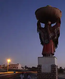 Statue at the western entrance to Souk Lahad depicting a local woman in traditional garb (here, seen from behind).
