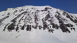 Storbukttind (literally, 'Big Bay Peak'; 1,054 meters or 3,458 feet) stands just west of route E6.