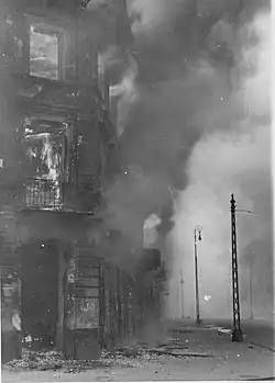 NARA copy #28 A housing block being destroyed Zamenhofa Street looking North, with burning Zamenhofa 25 / Wołyńska 2 on the left.
