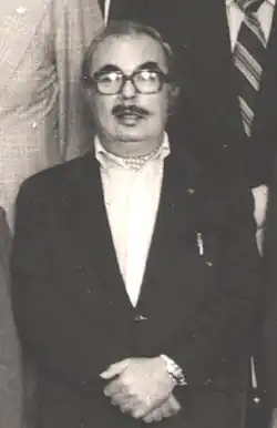 Black-and-white portrait of Sydney Newman, then an elderly man with a moustache wearing glasses and a suit.