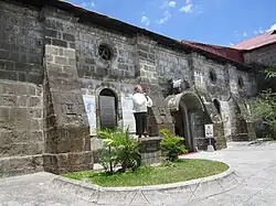 Church walls featuring buttresses and a monument of Saint Lorenzo Ruiz