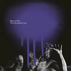 A black-and-white photo of a sculpture of a man with a long beard covering his face with a large splatter of purple paint on the top and the album and band name in white type