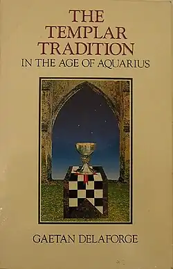 Cover reads at the top The Templar Tradition in the Age of Aquarius. Reads at the bottom Gaetan Delaforge. In the middle of the cover is a painting of a grail on a checkered Knights Templar flag, with a night sky background.