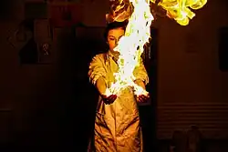 A young woman holding a flame in her hands