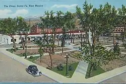 The plaza's extents are seen from above the southwest corner; a jalopy is seen on the left