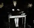 Magicians Julien Proskauer (left) and Hardeen (right) revealing a fraudulent method of table-turning. Both wore wrist bands with metal hooks to lift the séance table.