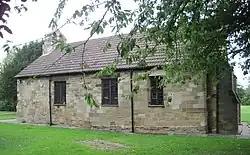Image of old church building with a tree obscuring the right end