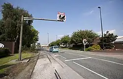 A photograph of a street with railway crossing lights on either side.