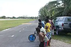 Tuvaluan children watching a plane land at Funafuti International Airport