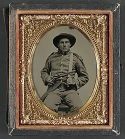 Private William Anthony Holland of Co. K, with Bowie knife and Colt Army Model 1860 revolver