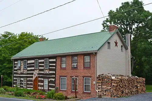 A log house with a brick addition