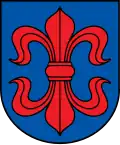 A coat of arms depicting a large, red fleur-de-lis that has a horizontal symmetry axis all on a blue background bordered by a black line