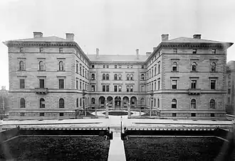 The Villard Houses as seen around 1890. There are six residences, which are arranged in a "U" shape around a courtyard; the residences have a unified appearance, making it seem like they are a single building.