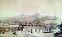 Watercolor depicting a man, dog and cart in front of a farm building, while in the background rise a series of hills on the slopes of which are forest, cattle and fields