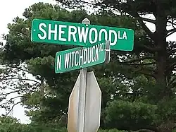 Sign reading 'Sherwood La' in one direction and N Witchduck Rd' in the other, in white lettering on a green background