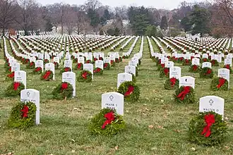 Thousands of balsam fir Christmas wreaths with red ribbons propped against headstones in Arlington National Cemetery in Arlington, Virginia, in the U.S.