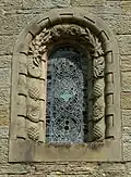 Stone window surround decorated with fossils, plants and pinecones at St Mary's, Wreay