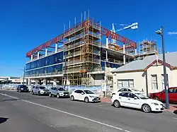 The clubhouse with a large building being built next door using a construction crane