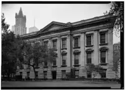 The eastern facade shaded by several trees