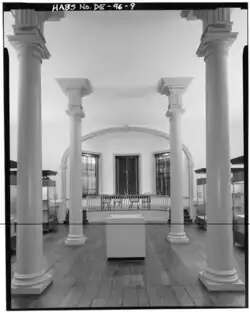 Black and white phote of large room with pillars
